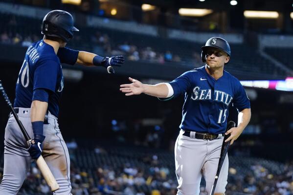 Seattle Mariners' Kyle Seager (15) celebrates his run scored against the Arizona Diamondbacks with teammate Jarred Kelenic (10) during the 11th inning of a baseball game Sunday, Sept. 5, 2021, in Phoenix. (AP Photo/Ross D. Franklin)