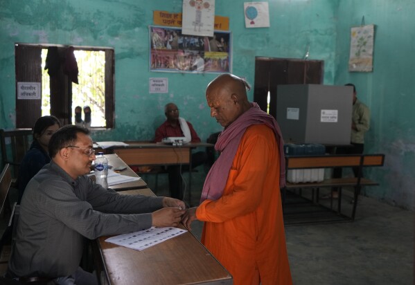 A polling officer applies indelible ink mark on the finger of a voter during the fifth round of multi-phase national elections in Ayodhya, India, Monday, May 20, 2024. (AP Photo/Rajesh Kumar Singh)