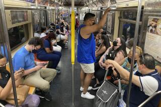 FILE — Commuters wear face masks while riding the subway in New York, June 6, 2021. New York state is dropping its mask requirement on public transportation thanks in part to the availability of new booster shots targeting the most common strain of COVID-19, Gov. Kathy Hochul announced Wednesday, Sept. 7, 2022. (AP Photo/Ted Shaffrey, File)