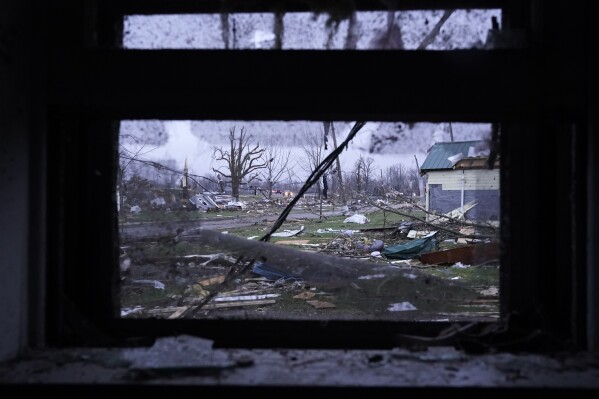 Debris is visible through the window of a damaged home following severe storms Friday, March 15, 2024, in Lakeview, Ohio. (AP Photo/Joshua A. Bickel)