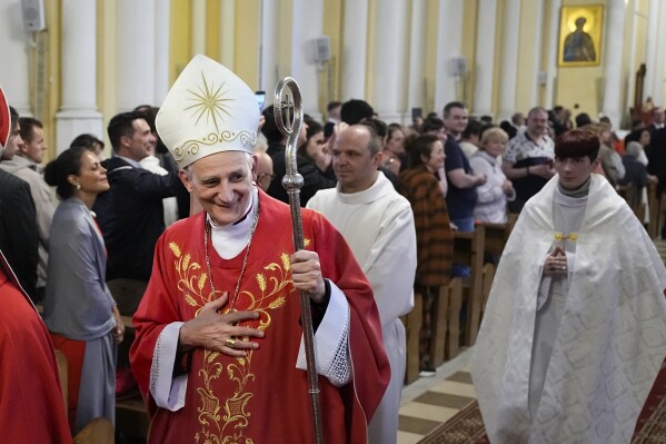 FILE - Cardinal Matteo Zuppi, head of the CEI (Italian Conference of Bishops), welcomes parishioners after celebrating Mass at the Cathedral of the Immaculate Conception in Moscow, on June 29, 2023. Pope Francis’ Ukraine peace envoy, Cardinal Matteo Zuppi, is heading to China on the fourth leg of a mission that has already brought him to Kyiv, Moscow and Washington, the Vatican said Tuesday.. (AP Photo/Alexander Zemlianichenko, file)