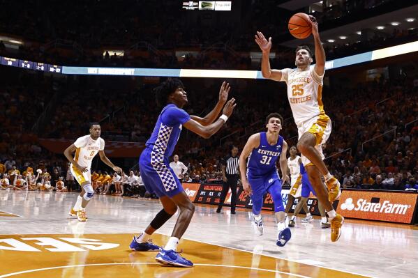 Tennessee guard Santiago Vescovi (25) shoots a layup past Kentucky guard Sahvir Wheelerand guard Kellan Grady (31) during the first half of an NCAA college basketball game Tuesday, Feb. 15, 2022, in Knoxville, Tenn. (AP Photo/Wade Payne)