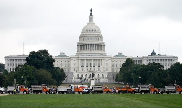 Dozens of dump trucks form a barrier as security measures are put into place before a rally near the U.S. Capitol in Washington, Saturday, Sept. 18, 2021. The rally was planned by allies of former President Donald Trump and aimed at supporting the so-called "political prisoners" of the Jan. 6 insurrection at the U.S. Capitol. (AP Photo/Gemunu Amarasinghe)