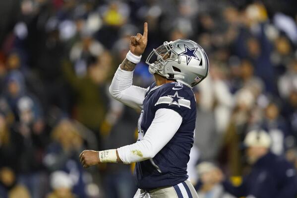 FILE - Dallas Cowboys quarterback Dak Prescott (4) points upward after scoring against Washington Commanders during the first half an NFL football game, Sunday, Jan. 8, 2023, in Landover, Md. While its Super Bowl commercial appearances are few, religion – Christianity especially – is entrenched in football culture. (AP Photo/Patrick Semansky, File)