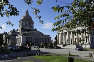 FILE - The afternoon sun illuminates the Legislative Building, left, at the Capitol in Olympia, Wash, Oct. 9, 2018. In a Tuesday, Feb. 6, 2024, vote, the Washington state Senate unanimously approved legislation that would ban police from hog-tying suspects, a restraint technique that has long drawn concern due to the risk of suffocation. (AP Photo/Ted S. Warren, File)