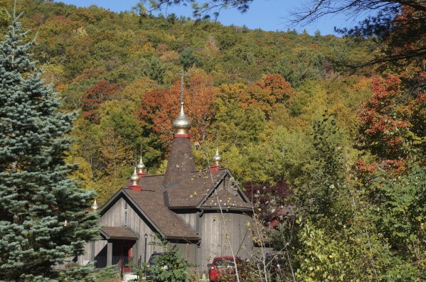 The Church of Holy Transfiguration, built by monks in 1970, is seen through fall foliage on the campus of New Skete, a Christian Orthodox monastery renowned for dog breeding and training programs outside Cambridge, N.Y., on Oct. 12, 2024. (AP Photo/Giovanna Dell’Orto)