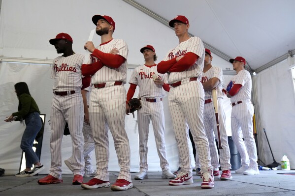 FILE - Philadelphia Phillies players wait to have their photo taken during a baseball spring training photo day Thursday, Feb. 22, 2024, in Clearwater, Fla. Baseball players鈥� association head Tony Clark is hopeful 2024 uniforms will soon be altered following complaints by his members. The uniforms designed by Nike and manufactured by Fanatics have been criticized by players for pants that are somewhat see through and for lettering, sleeve emblems and numbering that are less bulky and apparently smaller.(APPhoto/Charlie Neibergall, File)