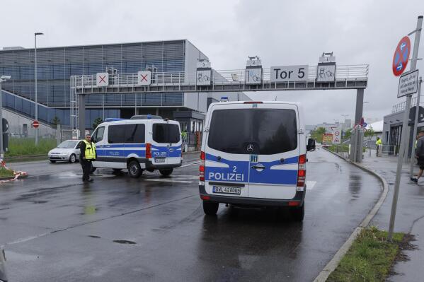 Police emergency vehicles are parked at a Mercedes-Benz plant in Sindelfingen, Germany, Thursday May 11, 2023.. A man opened fire at a Mercedes-Benz factory in southwestern Germany on Thursday, leaving one person dead and another person seriously wounded, German prosecutors confirmed. (Julian Rettig/dpa via AP)