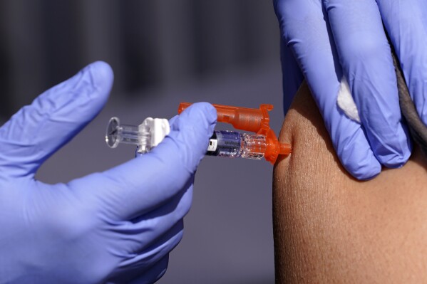 FILE - A patient is given a flu vaccine Friday, Oct. 28, 2022, in Lynwood, Calif. Seasonal flu continues to pick up steam in the U.S. But among respiratory viruses, COVID-19 remains the main cause of hospitalizations and deaths, health officials said Friday, Dec. 1, 2023. (AP Photo/Mark J. Terrill, File)