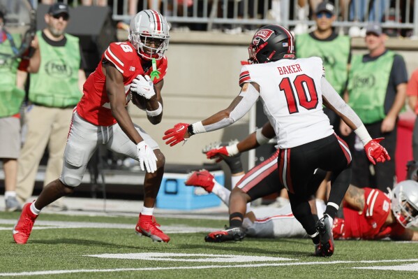 Ohio State receiver Marvin Harrison, left, runs after a catch as Western Kentucky linebacker Desmyn Baker defends during the first half of an NCAA college football game, Saturday, Sept. 16, 2023, in Columbus, Ohio. (AP Photo/Jay LaPrete)