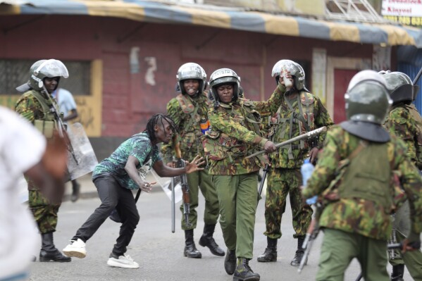 FILE - Police clash with a man during a protest by supporters of Kenya's opposition leader Raila Odinga over the high cost of living and alleged stolen presidential vote, in Nairobi, on March 20, 2023. The United States is praising Kenya's interest in leading a multinational force in Haiti. But weeks ago, the U.S. openly warned Kenyan police officers against violent abuses. Now 1,000 of those police officers might head to Haiti to take on gang warfare. (AP Photo/Brian Inganga, File)