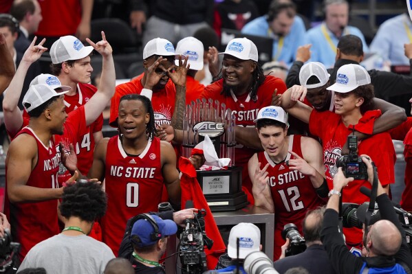 North Carolina State players with the trophy after winning an NCAA college basketball game against North Carolina to win the championship of the Atlantic Coast Conference tournament, Saturday, March 16, 2024, in Washington. North Carolina State won 84-76. (AP Photo/Susan Walsh)