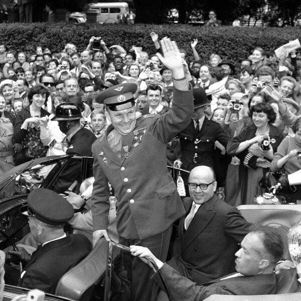 FILE - In this July 15, 1961 file photo, Major Yuri Gagarin, the Russian astronaut, waves his greeting to spectators as he leaves the Soviet Embassy in London, United Kingdom, after his visit to Britain. He was mobbed by hundreds of onlookers and well-wishers as he drove from the embassy to London airport. The successful one-orbit flight on April 12, 1961 made the 27-year-old Gagarin a national hero and cemented Soviet supremacy in space until the United States put a man on the moon more than eight years later. (AP Photo/Dennis Lee Royle, File)