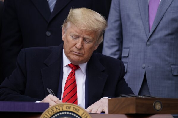 President Donald Trump signs a new North American trade agreement with Canada and Mexico, during an event at the White House, Wednesday, Jan. 29, 2020, in Washington. (AP Photo/ Evan Vucci)