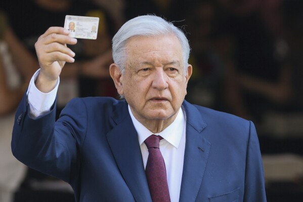 Outgoing President Andrés Manuel López Obrador shows his ID after voting in general elections in Mexico City, Sunday, June 2, 2024. (AP Photo/Ginnette Riquelme)