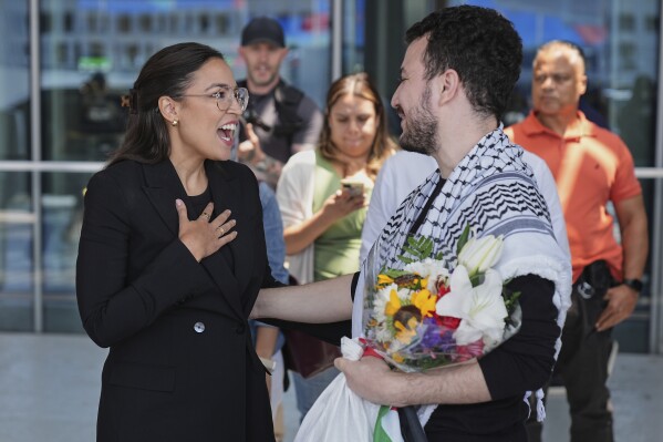 Mahmoud Khalil, right, speaks to Rep. Alexandria Ocasio-Cortez, D-N.Y., after arriving at Newark International Airport, Saturday, June 21, 2025, in Newark, N.J. (AP Photo/Seth Wenig)