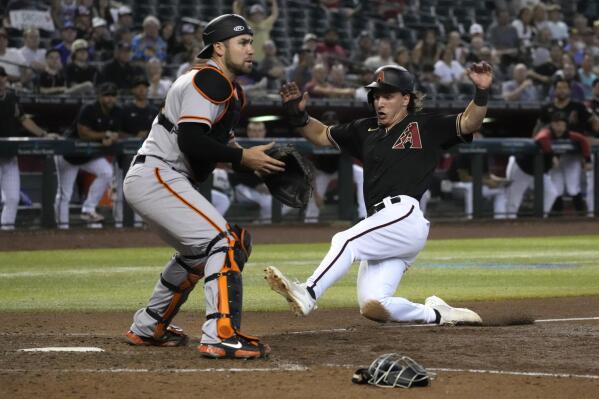 Arizona Diamondbacks' Jake McCarthy, right, scores on an error by San Francisco Giants first baseman Brandon Belt during the seventh inning of a baseball game Wednesday, July 27, 2022, in Phoenix. (AP Photo/Rick Scuteri)