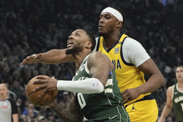 Milwaukee Bucks' Damian Lillard gets past Indiana Pacers' Myles Turner during the first half of Game 1 of the NBA playoff basketball game Sunday, April 21, 2024, in Milwaukee. (AP Photo/Morry Gash)