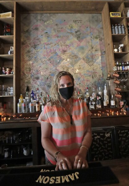 Danielle Savin, co-owner of a bar called Bob's Your Uncle, poses for a photo, Tuesday, June 30, 2020, at the bar in Miami Beach, Fla. Savin owns two bars that were forced to shut down for months in both New York and Miami Beach. When the pandemic first hit and New York was the country's epicenter she feared for that business, but months later the two states have flip-flopped. (AP Photo/Wilfredo Lee)