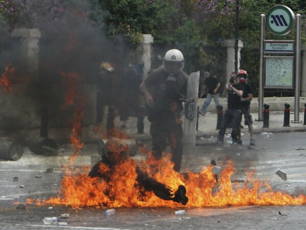FILE - In this Wednesday, May 5, 2010, file photo, a riot police officer is engulfed in flames from a fire bomb thrown by protesters in central Athens, during a protest against harsh new spending cuts aimed at saving their country from bankruptcy. The debt crisis in Europe and particularly in Greece raised serious questions in Britain about developments in the European Union even though Britain did not use the euro currency, contributing to the Brexit vote in June 2016. Britain is scheduled to leave the EU on Jan. 31, 2020 after 47 years of membership. (AP Photo/Thanassis Stavrakis, File)