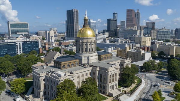 FILE - The gold dome of the Georgia Capitol gleams in the sun, Aug. 27, 2022, in front of the skyline of downtown Atlanta. Legislation that would ban some citizens of China from owning farmland in Georgia is advancing at the state Capitol despite criticism that it promotes xenophobia and could face legal hurdles. (AP Photo/Steve Helber, File)