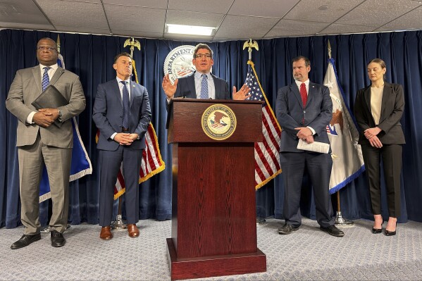 Acting United States Attorney Joshua Levy speaks, Wednesday, Feb. 14, 2024, during a news conference at the federal courthouse in Boston, about charges brought against 40 gang members in Boston that include drug trafficking, COVID fraud and racketeering. (AP Photo/Michael Casey)