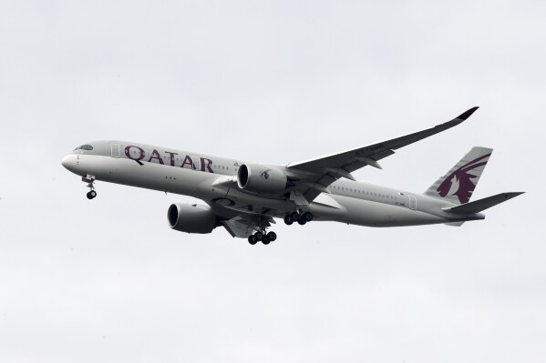 FILE - A Qatar Airways jet approaches Philadelphia International Airport in Philadelphia, Nov. 7, 2019. An Australian court on Wednesday, April 10, 2024, has rejected a case brought by five women seeking compensation from Qatar Airways over invasive gynecological examinations conducted on passengers at Doha’s airport in 2020. The women's case against the airport's operator is still going ahead, however. (AP Photo/Matt Rourke, File)