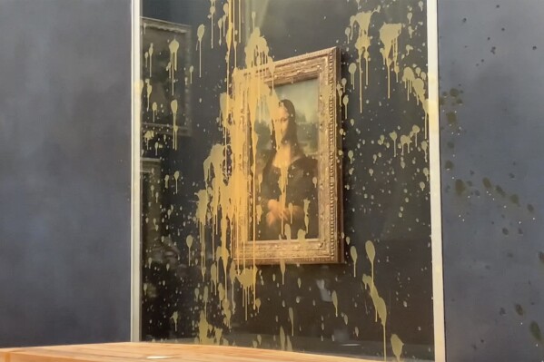 In this grab taken from video, a view of the scene after activists hurled soup at the glass protecting the Mona Lisa, at the Louvre Museum, in Paris, Sunday. Jan. 28, 2024. The two activists shouted slogans advocating for a sustainable food system. It comes as French farmers have been protesting for days across the country against several issues, including low wages. (AP Photo/Clement Lanot)