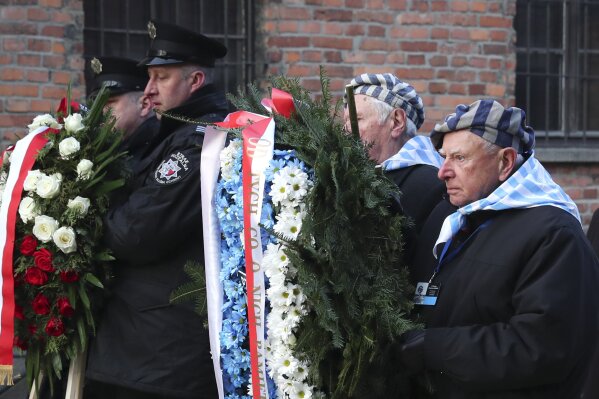 Survivors carry a wreath at the Auschwitz Nazi death camp in Oswiecim, Poland, Monday, Jan. 27, 2020. Survivors of the Auschwitz-Birkenau death camp gathered for commemorations marking the 75th anniversary of the Soviet army's liberation of the camp, using the testimony of survivors to warn about the signs of rising anti-Semitism and hatred in the world today.(AP Photo/Czarek Sokolowski)