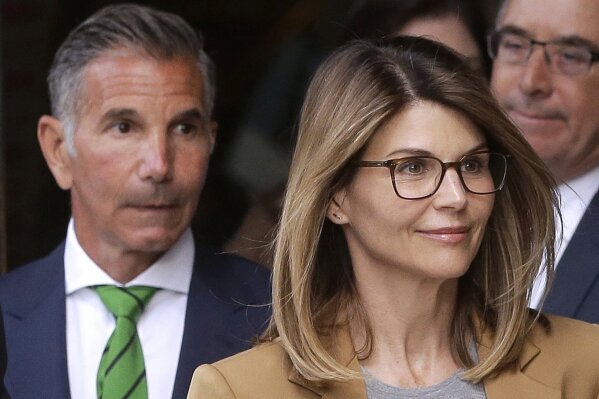 FILE - In this April 3, 2019, file photo, actress Lori Loughlin, front, and her husband, clothing designer Mossimo Giannulli, left, depart federal court in Boston after a hearing in a nationwide college admissions bribery scandal. A federal judge on Friday, May 8, 2020, refused to dismiss charges against the couple and other prominent parents accused of cheating in the college admissions process, siding with prosecutors who denied that investigators had fabricated evidence. (AP Photo/Steven Senne, File)