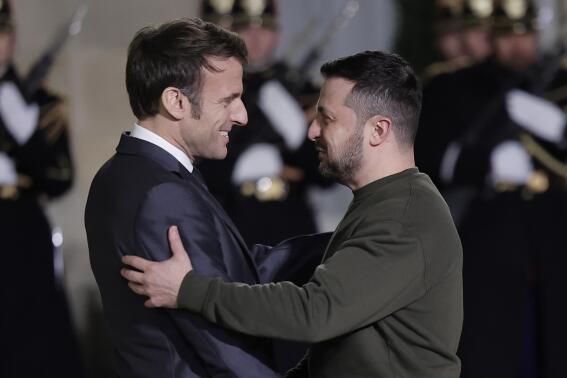 French President Emmanuel Macron, left, welcomes Ukrainian President Volodymyr Zelenskyy at the Elysee Palace before a working diner with German Chancellor Olaf Scholz, Wednesday, Feb. 8, 2023 in Paris. Western support has been key to Kyiv's surprisingly stiff defense, and the two sides are engaged in grinding battles. (AP Photo/Lewis Joly)