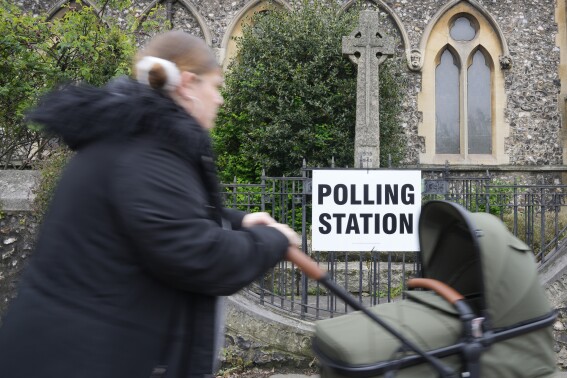 FILE - A woman pushes a buggy as she arrives to vote at a polling station in London, Thursday, May 2, 2024. Britain's governing Conservative Party is suffering heavy losses as local election results pour in Friday, piling pressure on Prime Minister Rishi Sunak ahead of a U.K. general election in which the main opposition Labour Party appears increasingly likely to return to power after 14 years. (AP Photo/Kin Cheung, File)
