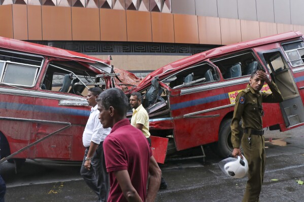 A security officer stands by a bus that was damaged when a tree fell on it in Colombo, Sri Lanka, Friday, Oct. 6, 2023. A large tree fell on the moving bus, killing five people and injuring five others, said Dr. Rukshan Bellana, a spokesperson for the capital’s main hospital. Heavy rain triggered floods and mudslides and downed trees in many parts of Sri Lanka. (AP Photo)