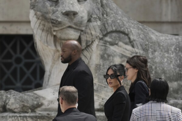 Kim Kardashian, center, arrives to testify regarding a robbery of millions of dollars in jewels from her Paris hotel room in 2016, in Paris, Tuesday, May 13, 2025. (AP Photo/Aurelien Morissard)