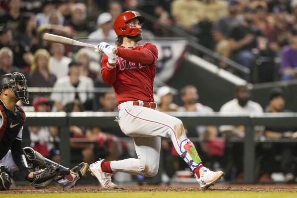 Philadelphia Phillies' Bryce Harper watches his home run against the Arizona Diamondbacks during the sixth inning in Game 5 of the baseball NL Championship Series in Phoenix, Saturday, Oct. 21, 2023. (AP Photo/Brynn Anderson)