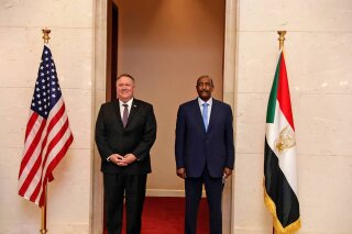 FILE - In this Aug. 25, 2020 file photo, U.S. Secretary of State Mike Pompeo stands with Sudanese Gen. Abdel-Fattah Burhan, the head of the ruling sovereign council, in Khartoum, Sudan.  Sudan's interim government has been splintered by intense pressure from the United States to normalize relations with Israel as the Trump administration seeks to burnish the president's statesmanlike credentials ahead of the November election.  (Sudanese Cabinet via AP, File)