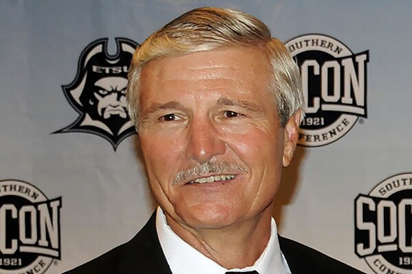 FILE - Carl Torbush poses after being introduced as the NCAA college football head coach at East Tennessee State, Friday, June 21, 2013, in Johnson City, Tenn. Torbush, a defensive specialist who succeeded Mack Brown as North Carolina's head football coach after Brown’s first tenure and later coached at East Tennessee State, has died. He was 72. ETSU said Monday that Torbush died Sunday, Nov. 5, 2023. (David Boyd/The Johnson City Press via AP, File)