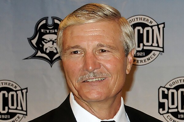 FILE - Carl Torbush poses after being introduced as the NCAA college football head coach at East Tennessee State, Friday, June 21, 2013, in Johnson City, Tenn. Torbush, a defensive specialist who succeeded Mack Brown as North Carolina's head football coach after Brown’s first tenure and later coached at East Tennessee State, has died. He was 72. ETSU said Monday that Torbush died Sunday, Nov. 5, 2023. (David Boyd/The Johnson City Press via AP, File)