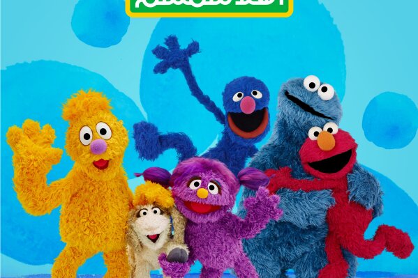 This image released by Sesame Workshop shows characters, from left, Jad, Ma'zooza, Basma, grover, background center, Cookie Monster and Elmo. Sesame Workshop — the nonprofit, educational organization behind “Sesame Street” — has teamed up with the International Rescue Committee — to launch a new, locally produced Arabic TV program "Welcome Sesame" for the hundreds of thousands of children dealing with displacement in Syria, Iraq, Jordan and Lebanon. (Sesame Workshop via AP)