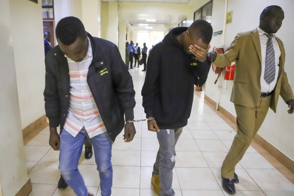 Alex Mutua Kithuka, center, and Albunus Mutinda Nzioki, left, who were arrested in connection with the murder of British national Campbell Scott, are whisked out of Milimani Law Court in Nairobi, Kenya, Monday, March 3, 2025. (AP Photo/Andrew Kasuku)