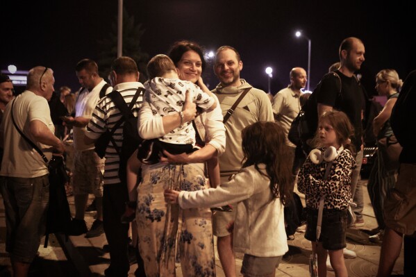 A family reacts as the first group of Bulgarian citizens evacuated from Israel, along with dozens of foreign nationals from Slovenia, the U.S., Belgium, Albania, Kosovo and Romania, arrive at Vassil Levsky airport in Sofia, Wednesday, June 18, 2025. (AP Photo/Valentina Petrova)