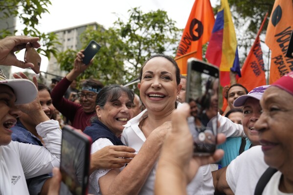 Opposition leader and presidential hopeful Maria Corina Machado, who has been banned from running for office, is embraced by supporters during a rally where she asked them to keep the faith, in San Antonio, Venezuela, April 17, 2024. The presidential election is scheduled to be held in Venezuela on July 28th. (AP Photo/Ariana Cubillos)