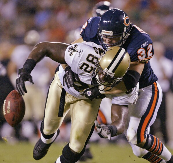 FILE - Chicago Bears' Todd Johnson (32) forces New Orleans Saints' Boo Williams (82) to fumble during the first quarter Friday, Aug. 27, 2004, in Chicago. Williams needs surgery, medicine and doctors to make the pain subside from injuries he endured during his football career. But he can't afford any of it. The 44-year-old was recently awarded $5,000 a month by the NFL's disability benefit plan. But Williams said the plan and the league have repeatedly mishandled his claims and should really have paid him $500,000 or more over the past 14 years. (AP Photo/Brian Kersey, File)