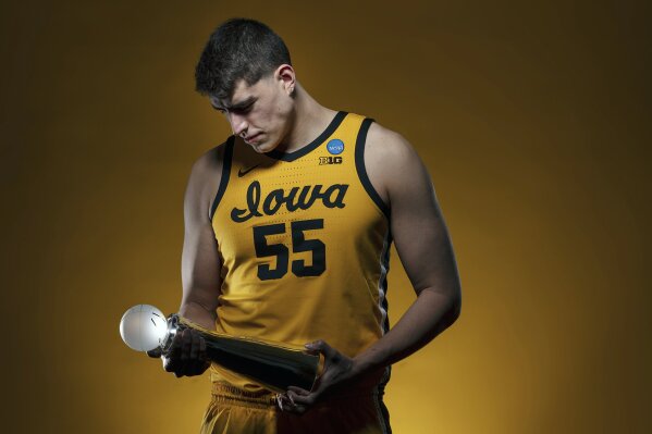 In this photo provided by the University of Iowa, Iowa NCAA college basketball center Luka Garza (55) holds the 2021 AP Player of the Year trophy on Wednesday, March 31, 2021, at Carver-Hawkeye Arena in Iowa City, Iowa. Garza was named The Associated Press men's basketball player of the year on Thursday, April 1. (Brian Ray/University of Iowa Athletics via AP)
