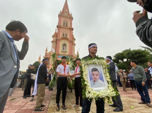 The brother of Hoang Van Tiep carries his portrait outside Trung Song church during his funeral on Thursday, Nov. 28, 2019, in Dien Chau, Vietnam. The 18-year old Tiep was among the 39 Vietnamese w...
