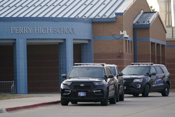 Police vehicles sit parked in front of Perry High School following a shooting Thursday at the school, Friday, Jan. 5, 2024, in Perry, Iowa. (AP Photo/Charlie Neibergall)