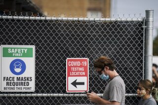 Patients wait on line outside a COVID-19 testing site that provides priority testing for NYC Department of Education staff through NYC Health + Hospitals on Ft. Hamilton Parkway, Wednesday, Oct. 7, 2020, in the Borough Park neighborhood of the Brooklyn borough of New York. (AP Photo/John Minchillo)