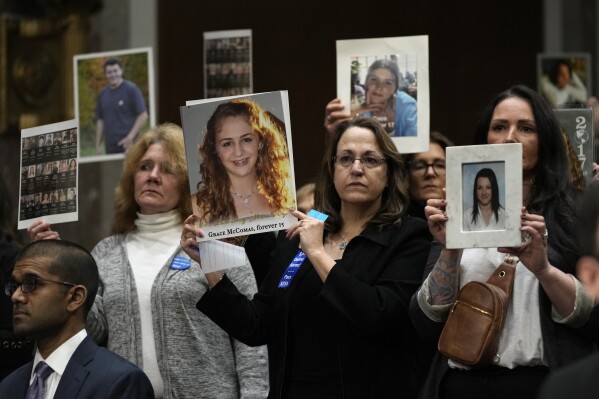 File - People show photos of their loved ones before the start of a Senate Judiciary Committee hearing with the heads of social media platforms on Capitol Hill in Wednesday, Jan. 31, 2024, to discuss child safety. The CEOs got grilled by Senate lawmakers in an emotional and often heated hearing about the dangers their platforms pose to children. (AP Photo/Susan Walsh, File)