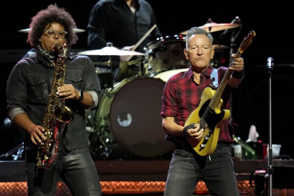 Bruce Springsteen, right, plays his guitar as Jake Clemons plays saxophone on stage during a concert of Bruce Springsteen and The E Street Band World Tour 2024 performance Tuesday, March 19, 2024, in Phoenix. (AP Photo/Ross D. Franklin)