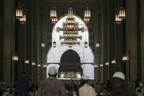 Muslim pilgrims stand in front the Kaaba, the cubic building at the Grand Mosque, during the annual Hajj pilgrimage, in Mecca, Saudi Arabia, Tuesday, June 3, 2025. (AP Photo/Amr Nabil)